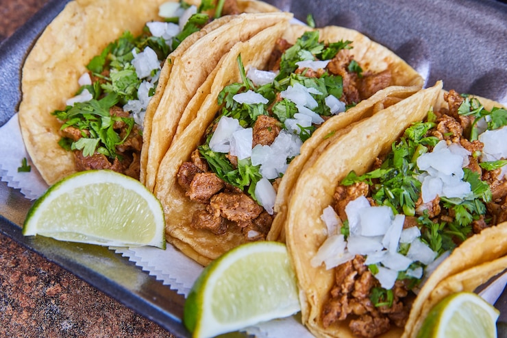 Foto bild von drei authentisches mexikanisches taco-steak mit zwiebeln, koriander und limette