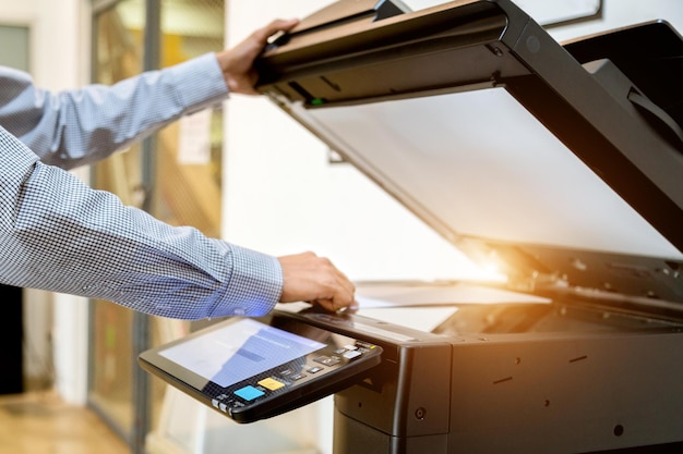 Foto bild von einem mann, der ein papierfotokopiergerät im büro druckt