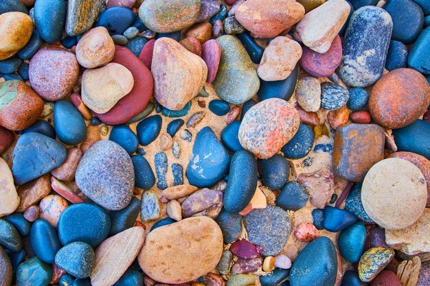 Bild von glatten bunten Steinen gegen einen Sandstrand