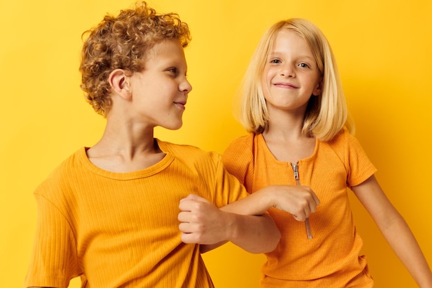 Bild von positiven Freizeitkleidungsspielen für Jungen und Mädchen, die zusammen auf farbigem Hintergrund posieren