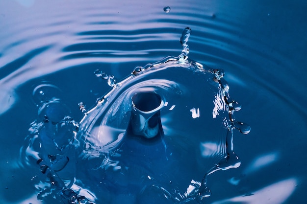 Bild von Wassertropfen, die auf der blauen Wasseroberfläche zusammenstoßen