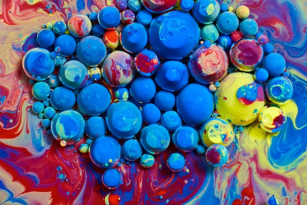 Bild von winzigen blauen Kugeln und Regenbogenkugeln, die auf der Oberfläche schweben