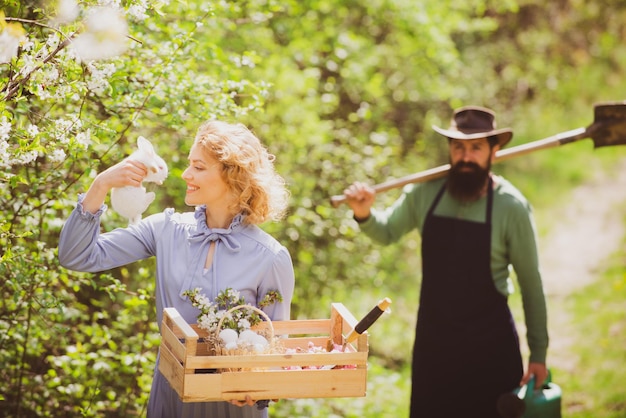 Bild von zwei glücklichen Bauern mit Instrumenten Ehefrau und Ehemann verbringen Zeit im Obstgarten eines Bauern und