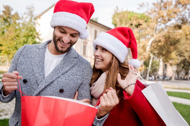 Bild, welches die jungen Paare tun das Weihnachtseinkaufen in der Stadt zeigt