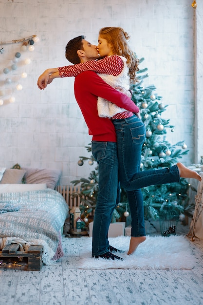 Bild zeigt junges Paar, das über Weihnachten umarmt und küsst