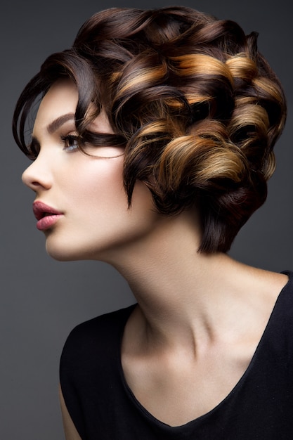 Bilden. Glamourporträt des schönen Frauenmodells mit frischem Make-up und romantischer gewellter Frisur.