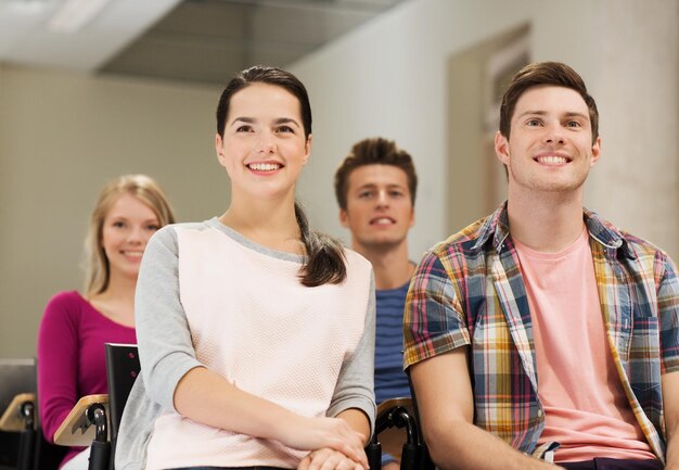 Bildung, Gymnasium, Teamwork und People-Konzept - eine Gruppe lächelnder Studenten, die im Hörsaal sitzen