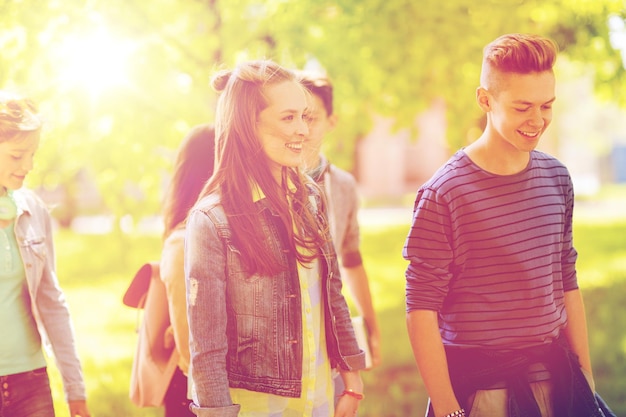 bildung, high school, kommunikation und personenkonzept - gruppe glücklicher jugendlicher, die im freien spazieren gehen