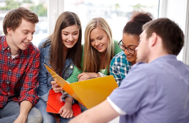 bildung, menschen, freundschaft und lernkonzept - gruppe glücklicher internationaler schüler oder klassenkameraden mit ordnern