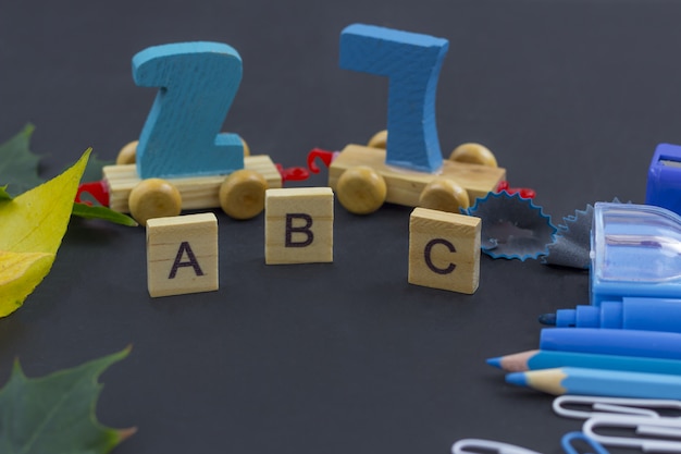 Bildung oder zurück in die Schule. Blauer Schulbedarf auf Tafel mit copyspace.