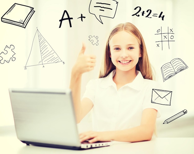 Bildung, Schule, Technologie und Internetkonzept - kleine Schülerin mit Laptop-PC in der Schule