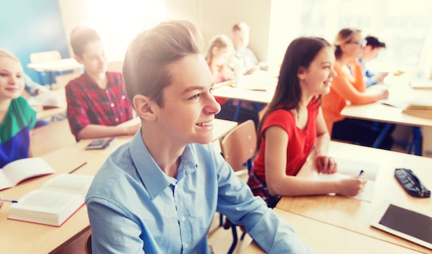 Bildung und Menschenkonzept Gruppe von Schülern mit Notizbüchern im Schulunterricht