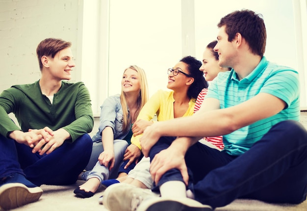 Bildungs-, Freizeit- und Glückskonzept - fünf lächelnde Teenager, die sich zu Hause amüsieren