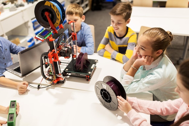 Bildungs-, Kinder-, Technologie-, Wissenschafts- und Menschenkonzept - Gruppe glücklicher Kinder mit 3D-Drucker und Laptop-Computer im Robotik-Schulunterricht