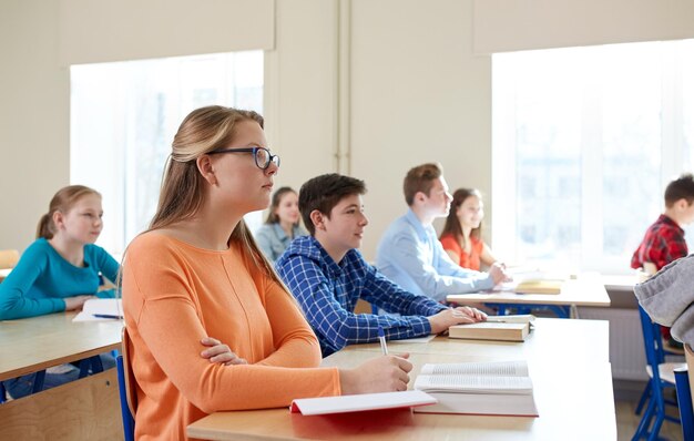 bildungs-, lern- und personenkonzept - gruppe von schülern mit büchern im schulunterricht