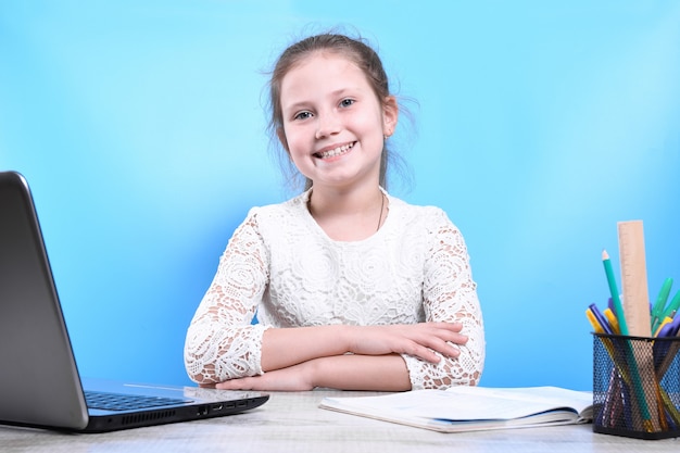 Bildungs-, Schul-, Technologie- und Internetkonzept - kleines Studentenmädchen mit Laptop-PC an der Schule. Fernlernen in Quarantäne.