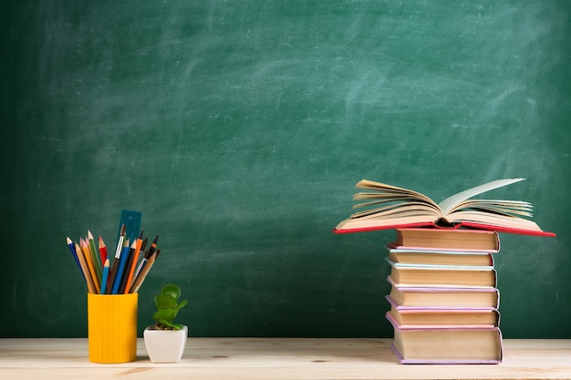 Bildungs- und Lesekonzept Gruppe bunter Bücher auf dem Holztisch im Klassenzimmer-Tafelhintergrund