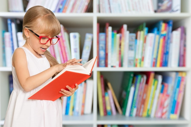 Bildungs- und Schulkonzept - kleines Studentenmädchen mit Buch isoliert auf weiß