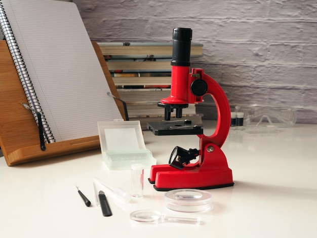 Bildungskonzept bucht Mikroskop-Laborgeräte auf dem Schreibtisch