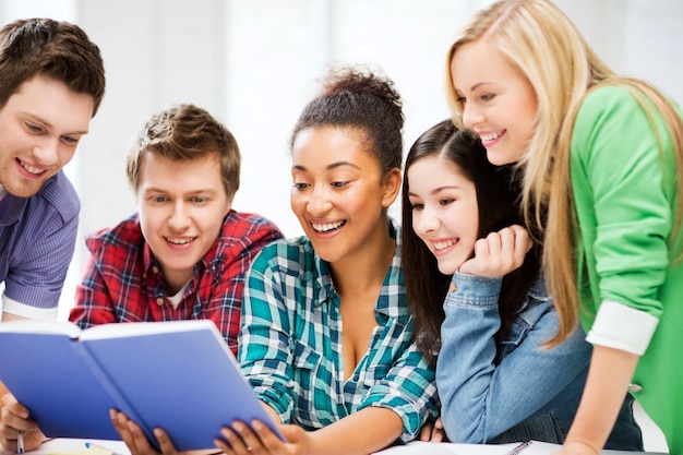 Bildungskonzept - Gruppe von Schülern, die in der Schule ein Buch lesen