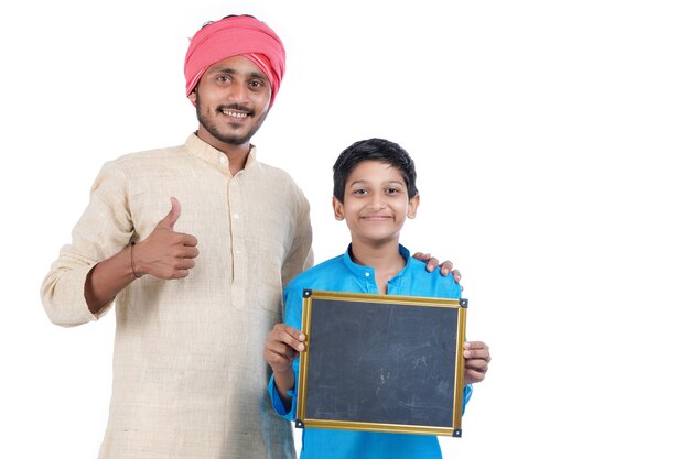 Bildungskonzept: Indischer Bauer mit seinem Kind, das leere Tafel auf weißem Hintergrund zeigt.