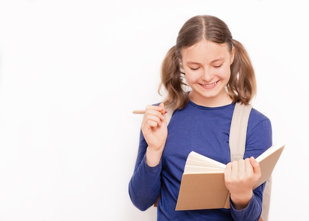 Bildungskonzept Lächelndes Teenager-Mädchen mit Buch und Bleistift auf dem grauen Hintergrund