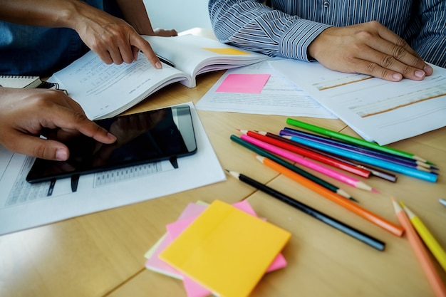 Bildungskonzept Studenten studieren und Brainstorming Campus-Konzept. Nahaufnahme von Studenten diskutieren ihr Thema auf Bücher Lehrbücher und Schreiben an Notebook. Selektiver Fokus