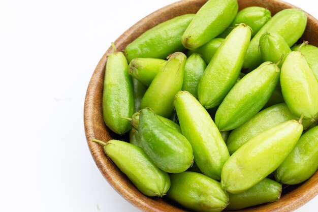 Bilimbi fruta en cesta de bambú sobre fondo blanco.