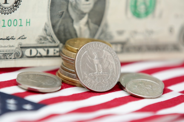 Billete de 1 dólar de los Estados Unidos con monedas y bandera en la parte inferior