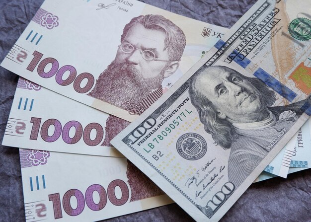 Billete de 100 dólares americanos y 1000 grivnas ucranianas