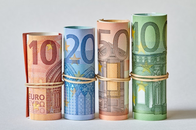 Billete de diez, veinte, cincuenta y cien euros enrollado como un túbulo. Detalles de los billetes en euros en un tiro macro. Primer plano, enfoque selectivo