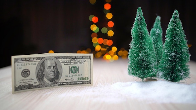 Foto billete de un dólar y árboles de navidad artificiales árbol de navidad y cien dólares