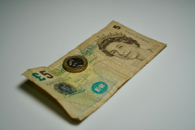 Foto un billete de una libra con una moneda en él