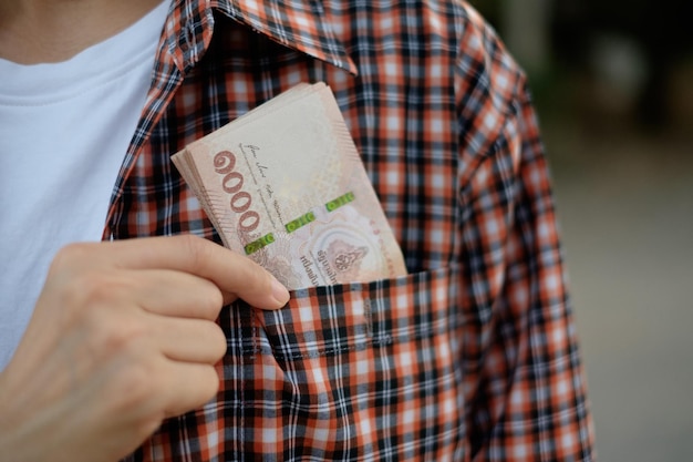 Billete de mil baht en el bolsillo de la camisa de un granjero