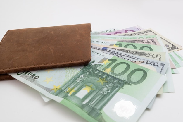 billetera con euro y dólares que sobresalen, aislada
