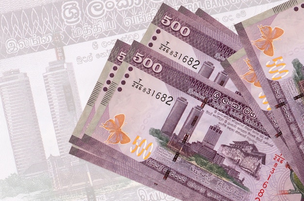 Billetes de 500 rupias de Sri Lanka se encuentra en la pila en el fondo del gran billete semitransparente.