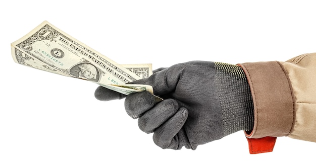 Billetes de dólar americano en mano de trabajador en guante protector negro y uniforme marrón aislado sobre fondo blanco.