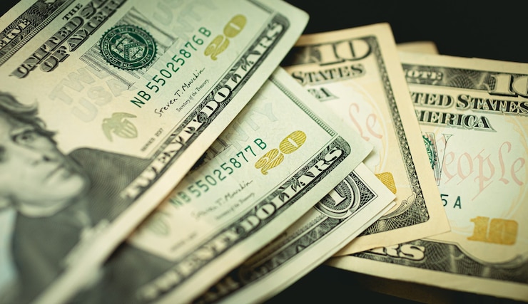 Foto billetes de dólar estadounidense en un ambiente oscuro en la foto en primer plano