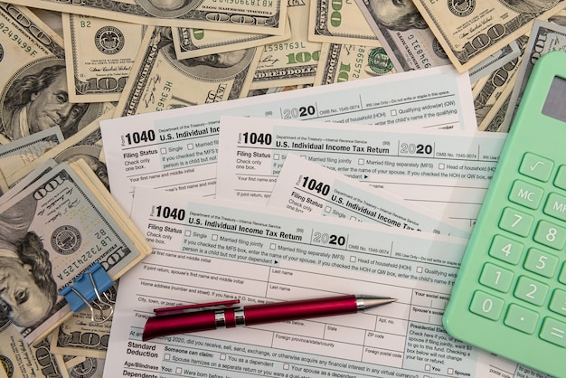 Billetes de dólar en el formulario de impuestos 1040 individual estadounidense, concepto de contador