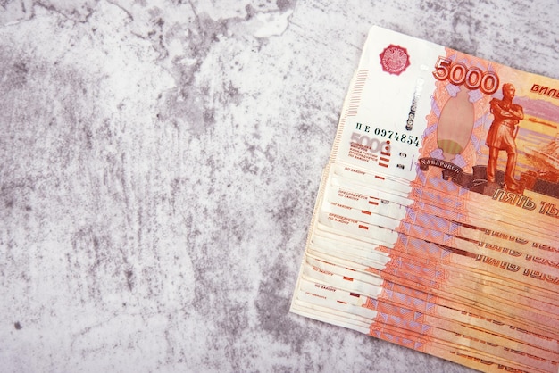 Billetes en efectivo rusos en denominaciones de cinco mil rublos el paquete se encuentra sobre un fondo gris