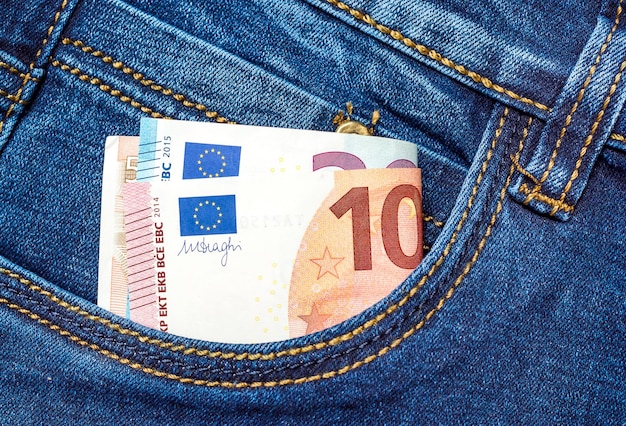 Billetes de euro doblados en el bolsillo delantero de los jeans