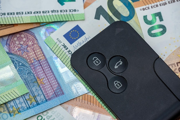 Billetes de euro y un seguro de inversión de automóvil de llave de coche