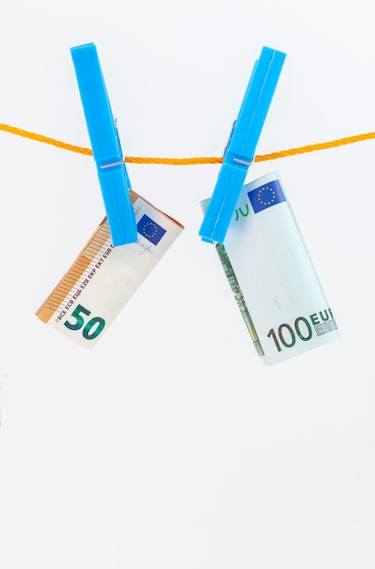 Los billetes en euros adjunta con pinzas para la ropa a una cuerda sobre fondo blanco aislado