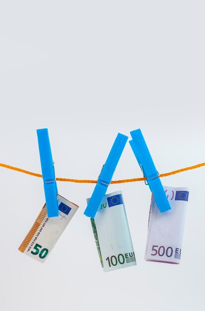 Los billetes en euros adjunta con pinzas para la ropa a una cuerda sobre fondo blanco aislado