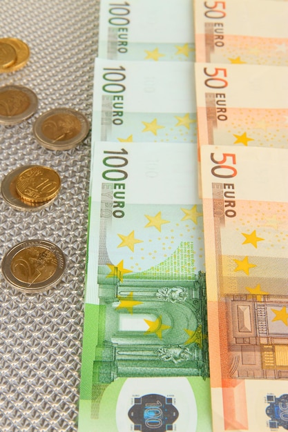 Billetes en euros y céntimos de euro sobre fondo gris