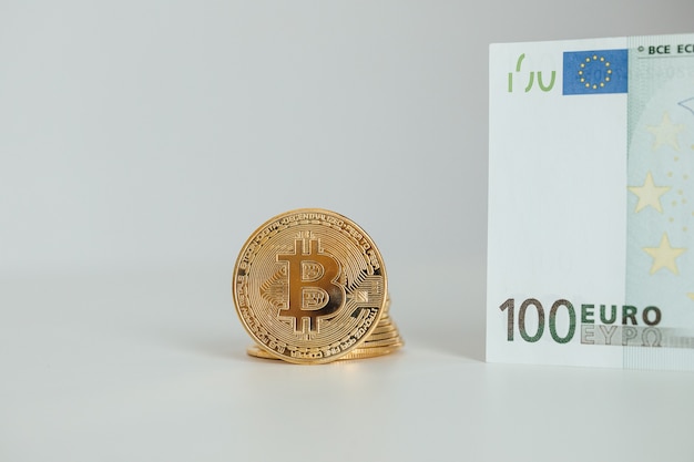 Billetes en euros y concepto de inversión en criptomonedas Bitcoin. Euro Money y Crypto moneda moneda bitcoin dorada.