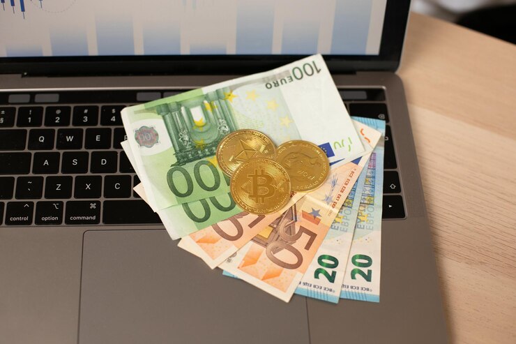 Billetes en euros y criptomonedas en un portátil de fondo con gráficos Gráfico de crecimiento de criptomonedas