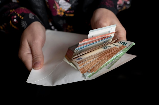 Foto billetes en euros en manos de un hombre sobre un fondo negro