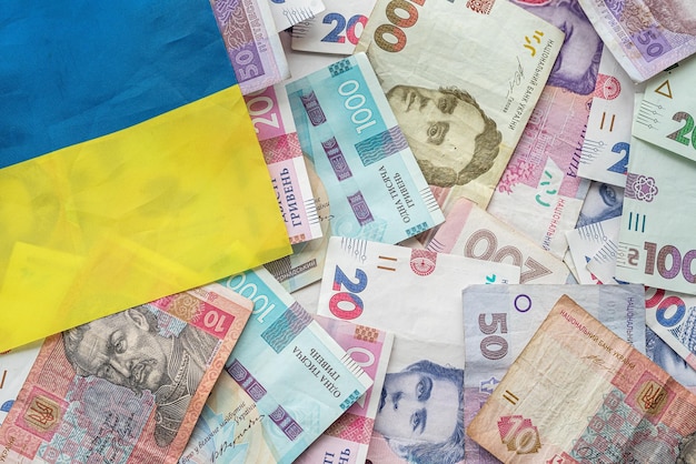 Foto billetes de hryvnia ucranianos en la bandera nacional de ucrania el concepto de símbolos ucranianos