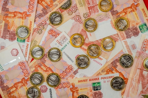 Billetes rusos de 5000 rublos y monedas sobre la mesa.